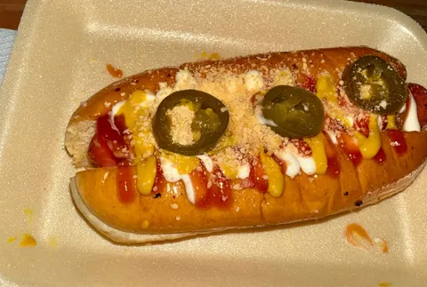 Hotdog con jalapeños, queso rallado, cátsup, mostaza y crema